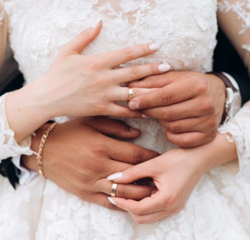 groom-bride-are-putting-wedding-rings-front-view-hands-min